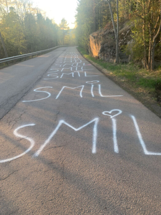 En vei med ordet "Smil" yagget på bakken